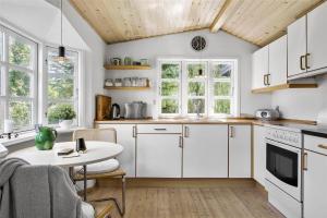 eine Küche mit weißen Schränken und einem Tisch in der Unterkunft 1007 Stege - Ulvshalevej 161 in Stege
