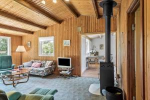 a living room with a fireplace and a couch at 5020-Askeby-Faergensvaenge-18 in Askeby