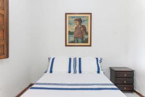 a bedroom with a bed with a picture on the wall at Bela Casa com Piscina-5 Quartos-SH106D in Bezerros +31 photos