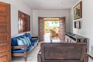 a living room with a blue couch and a table at Bela Casa com Piscina-5 Quartos-SH106D in Bezerros
