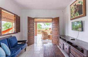 a living room with a blue couch and a tv at Bela Casa com Piscina-5 Quartos-SH106D in Bezerros