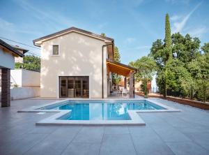 a swimming pool in front of a house at Casa Eva in Opric