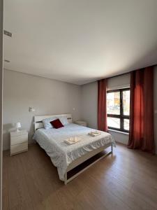 a bedroom with a bed and a large window at Apt 3 Quartos na Covilhã perto da Serra da Estrela in Covilhã