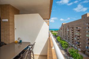 a balcony with a table and a view of a city at JARDINES DEL MAR II Vitamina D todo el año entre playa y montaña in El Borseral