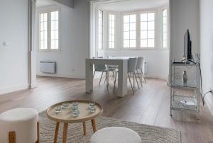 Una sala de estar blanca con una mesa y sillas. en Prestige & Vue Mer a Trouville, en Trouville-sur-Mer 9 fotos más