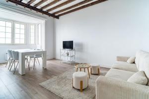 Una sala de estar blanca con un sofá y una mesa. en Prestige & Vue Mer a Trouville, en Trouville-sur-Mer