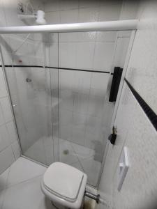 a white bathroom with a shower and a toilet at Prainha apto 202 in São Vicente