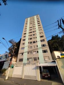 a tall building with a car parked in front of it at Prainha apto 202 in São Vicente