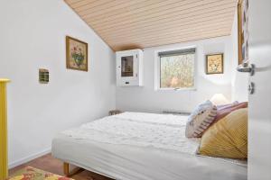 a bedroom with a white bed with a window at R963-Rodvig-Skovstumperne-3 in Rødvig
