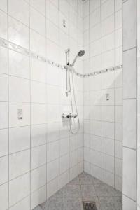 a bathroom with a shower with white tiled walls at R963-Rodvig-Skovstumperne-3 in Rødvig +15 photos