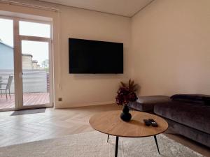a living room with a couch and a tv on the wall at The Sauna Terrace Home in Kuressaare