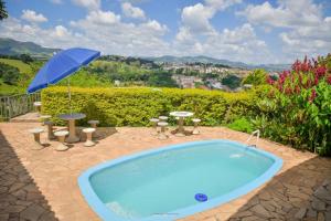 una piscina con sombrilla, mesa y sillas en Vista Linda, en Socorro