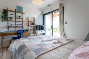 a bedroom with a bed and a desk and a window at Villa Douceur d'Océane in Biscarrosse +49 photos