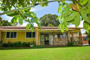 una casa amarilla con un patio verde en Vista Linda, en Socorro
