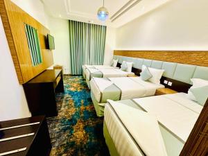 a hotel room with three beds at فندق ديار العروبة Diyar Al Arouba Hotel in Jarwal