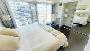 a bedroom with a large white bed and a mirror at Pantages Skyline Suite in Toronto Centre - Free Parking in Toronto