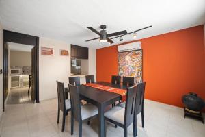 ein Esszimmer mit orangefarbenen Wänden sowie einem Tisch und Stühlen in der Unterkunft ALTABRISA Casa Familiar en Merida in Mérida