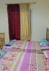 two beds sitting next to each other in a bedroom at VIP Chalet at JULIANA North coast جوليانا الساحل الشمالي in Dawwār Muşādif Yūnus