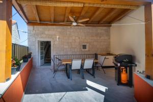 a patio with a table and chairs and a ceiling at Kuca za odmor Duje in Supetar