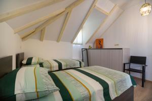 a bedroom with two beds and a chair at Kuca za odmor Duje in Supetar