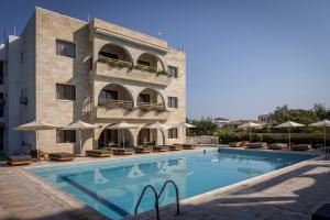 a hotel with a swimming pool in front of a building at Stephanos Hotel Apartments in Polis Chrysochous
