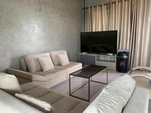 a living room with two couches and a flat screen tv at Phu Man Mhok Khao Yai in Ban Nong Takhain