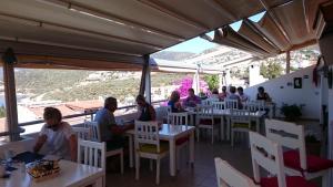a group of people sitting at tables in a restaurant at Courtyard in Kalkan