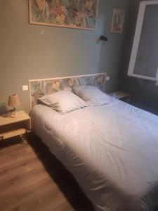 a bedroom with a bed with white sheets and a lamp at 1er etage d'une maison in Sorgues +8 photos