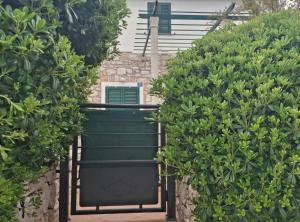 a set of two trees with a green gate at Villa Jagoda in Potomje