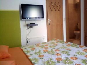 スペタルにあるRooms Tatjanaのベッドルーム1室(ベッド1台、壁掛けテレビ付)