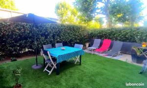 una mesa con sillas y una sombrilla en un patio en Le St benezet 1, en Aviñón