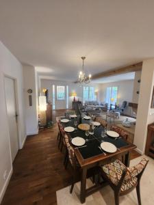 a dining room and living room with a table and chairs at Villa Piscine près Golf Arcachon in La Teste-de-Buch