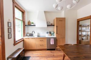 a kitchen with wooden cabinets and a wooden table at Chalet Edward & Walter Feuz - Edelweiss Village in Golden