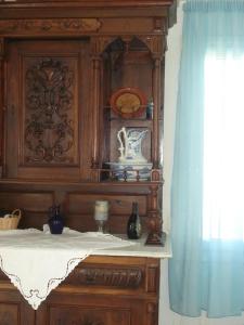 a large wooden cabinet with a table and a blue curtain at Sikinos Best View in Alopronia