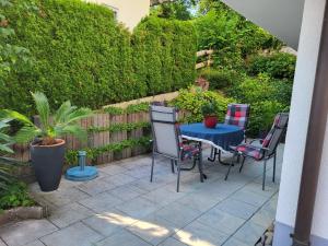 a patio with a blue table and four chairs at Ferienwohnung Schiffner in Hengnau