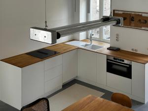 a white kitchen with a sink and a stove at U3 Loft in Varaždin