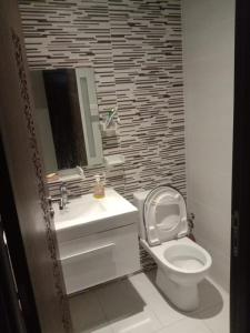 a bathroom with a white toilet and a sink at jnane ali akioud Gueliz in Marrakech