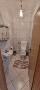a bathroom with a toilet and a sink at Apartman Ivan in Tomislavgrad +3 photos