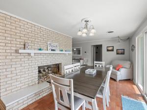 a dining room and living room with a brick fireplace at The Sea Glass House in Rockport