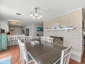 a dining room with a table and a brick fireplace at The Sea Glass House in Rockport +41 photos