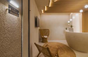 a bathroom with two chairs and a large tub at Golden Bay Suites & Maisonettes in Parga