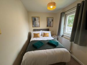 a bedroom with a bed with two pillows on it at DONALD'S Townhouse - INVOICE and REDUCED PRICE only via ORION SHORT STAYS DUNDEE, 4 Room, 3 bath, Ring Road Access, Fully Equipped, Free Parking - Freshly Renovated in Dundee