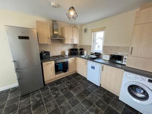 a kitchen with a refrigerator and a dishwasher at DONALD'S Townhouse - INVOICE and REDUCED PRICE only via ORION SHORT STAYS DUNDEE, 4 Room, 3 bath, Ring Road Access, Fully Equipped, Free Parking - Freshly Renovated in Dundee +17 photos