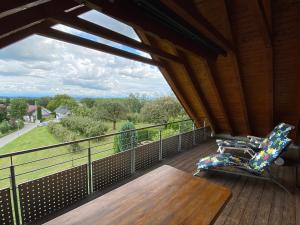 a deck with a chair and a table and a view at Ferienwohnung Karin in Oberteuringen