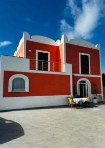 a red and white house with a table and chairs at Relais Villa Verde in Ventotene +20 photos