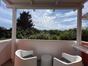 a balcony with two white chairs and a view at Relais Villa Verde in Ventotene +20 photos