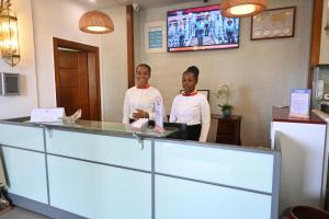 two women standing behind a counter in a restaurant at Grand Hôtel City - Akwa in Douala