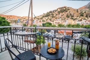a balcony with a table with donuts and orange juice at La Casa di Symi - Central Apartment with View in Symi