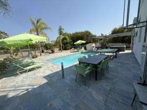 un patio con tavolo e sedie e una piscina di Villa Coralia Gardens 1km From Coral Bay Beach a Coral Bay