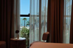 ドゥラスにあるZins Luxury Apartmentsのヤシの木の景色を望む窓付きのベッドルーム1室